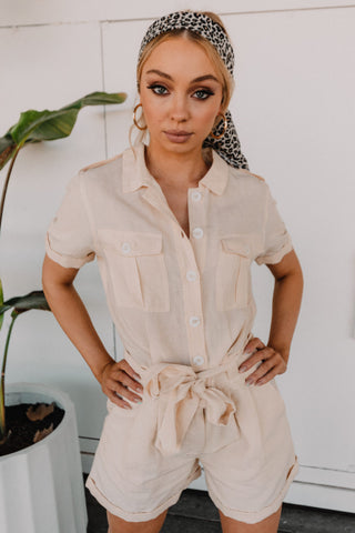 Model wearing cream playsuit styled with bandana