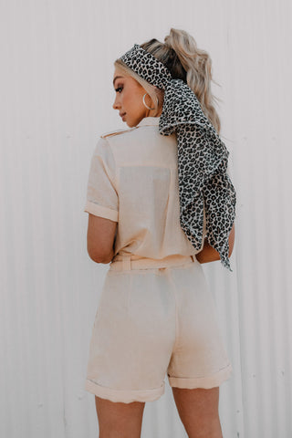 Back view of cream linen playsuit styled with bandana.