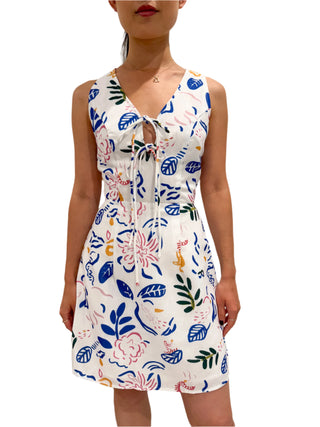 Floral print mini dress with fitted bodice and a-line skirt styled with heart necklace.