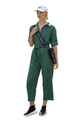 Green button up jumpsuit street styled with cross body bag, sneakers and cap.