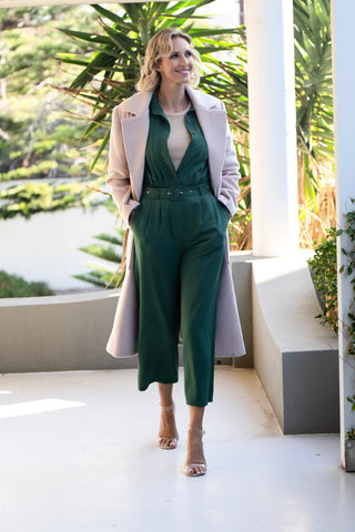 Rebecca Morse wearing our green jumpsuit styled with cream wool blend coat