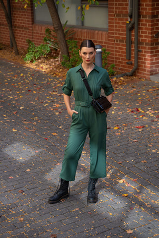 Utility style jumpsuit styled with black cross body bag and black utility boots.