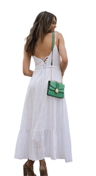 White dress with lace up back detail styled with green bag.
