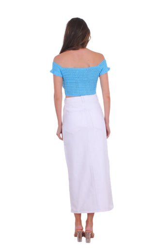 Back view of white denim midi skirt styled with a blue top.
