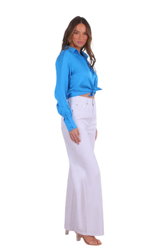 Side view of white denim jeans styled with blue shirt.