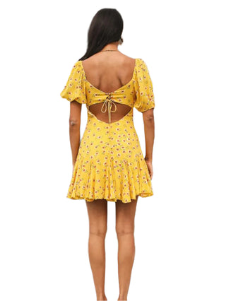 Back view of yellow printed dress with cut out back and tie