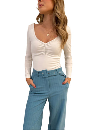 Close view of the ruching on the v neck long sleeve white top.