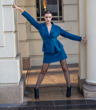 Stand out high fashion skirt suit styled with fishnet stockings and boots