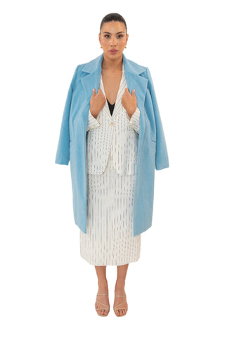 Blue wool blend coat worn over the shoulders layered over pinstripe blazer and matching skirt.