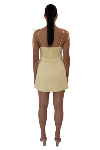 Back view of yellow mini dress with ruched elastic back panel.