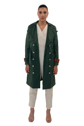 Green trench coat open over cream jumpsuit.