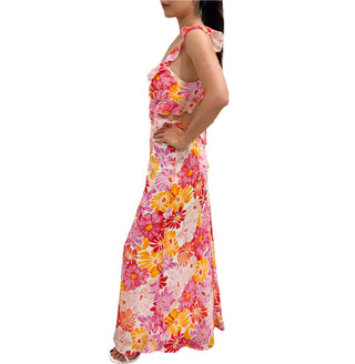 Side view of printed maxi dress with yellow, red, white and prink flowers, side cut-out and ruffles.