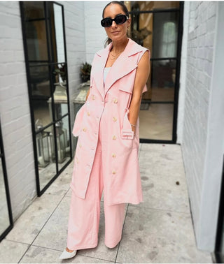 Alicia Sarah Hamidi wearing our pink long line vest and matching pants styled with black sunglasses and white points