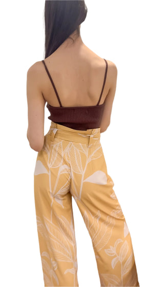 Back view of brown singlet strap ribbed knit top styled with printed high waisted paperbag pants.