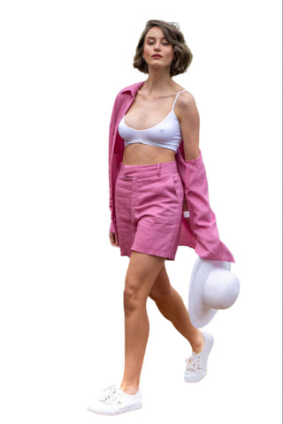 Fuchsia shorts with matching shirt, styled with white sneaker, white crop and white hat.