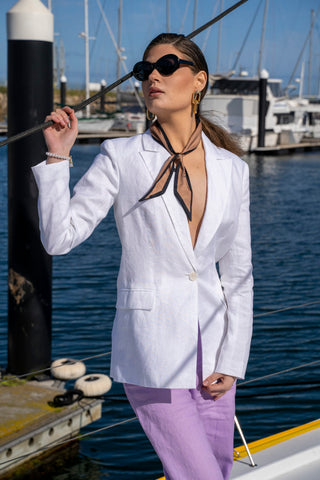 White linen blazer closed over lilac linen pants.