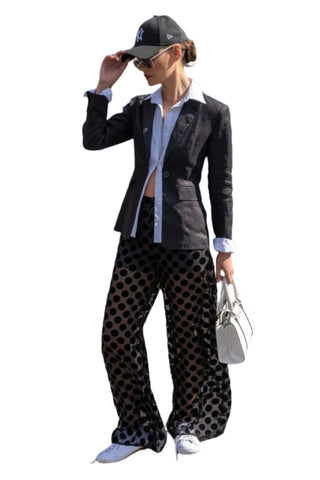 Black blazer with attached white shirt street styled with polka dot pants, sneakers and black cap.