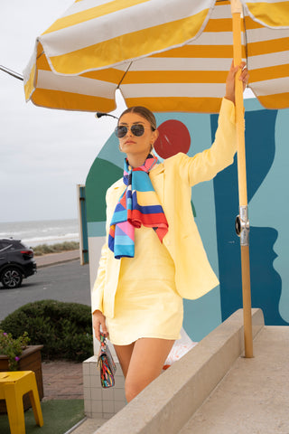 European fashion yellow blazer and matching dress set styled with neck scarf, multi colour bag and sunnies.