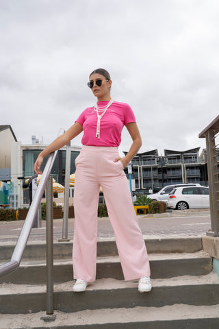 Street style high waisted pink pant styled with pink t shirt and sneakers.