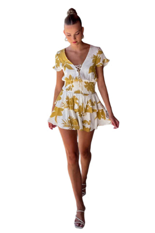 Model walking in white and yellow mini dress showing the movement in the skirt.