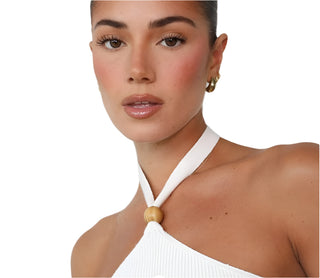 Close up view of white knit halter top and bead detail.