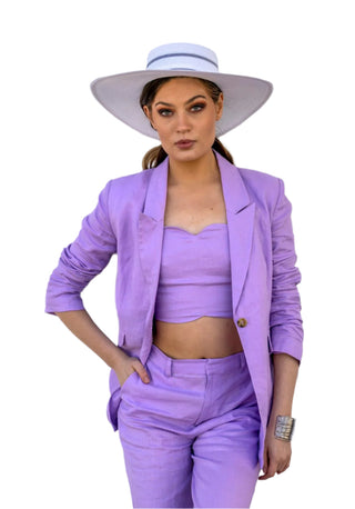Model layering lilac crop top with matching blazer and pant set in linen fabric.