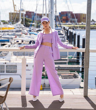 Three piece matching set - lilac linen blazer, crop top and pant, styled with lilac cap and white heel.