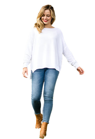Model wearing white long sleeve sheer kit with denim and boots.